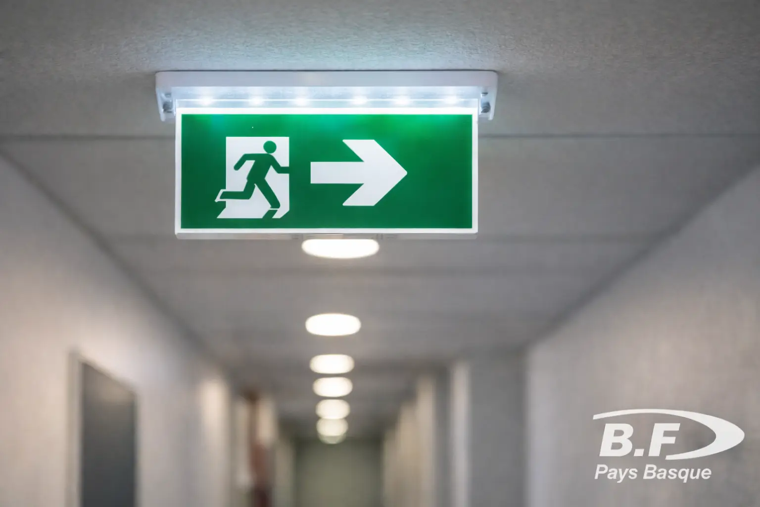 Panneau de sortie avec éclairage de sécurité dans un couloir